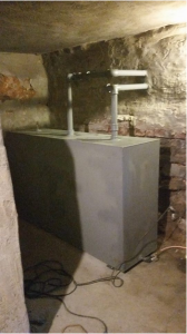A rectangular oil tank in an old basement.