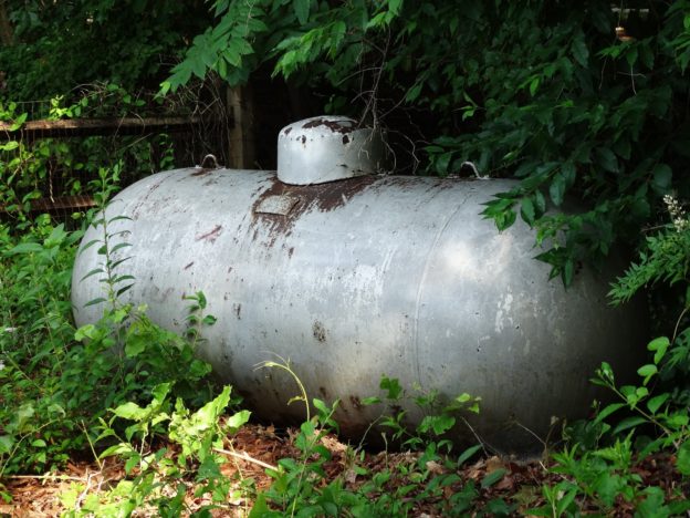 Overgrown above ground oil tank